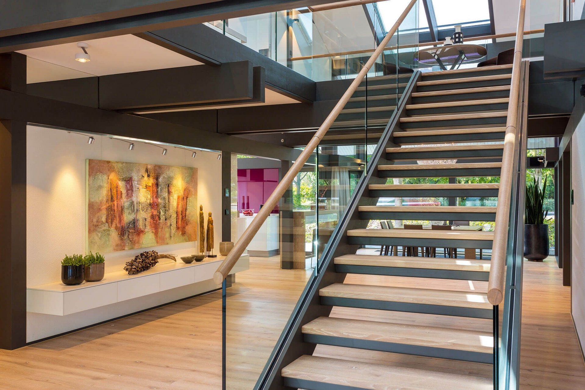 Modernes Treppenhaus mit Kunstwerk und Glasdetails Gepflegtes Foyer mit Treppe, Kunstwerk und modernen Möbeln