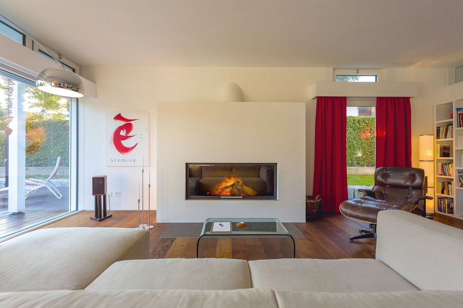 Helles Wohnzimmer mit Kamin, rotem Vorhang und moderner Einrichtung