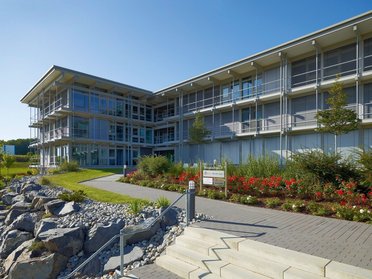 Ansicht eines modernen Bürogebäudes mit Garten und Landschaftsgestaltung