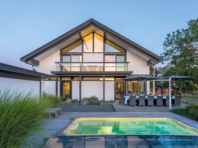 Moderne Architektur mit Pool und Glasfronten Ein modernes Haus mit großen Fenstern und einem Swimmingpool im Vordergrund