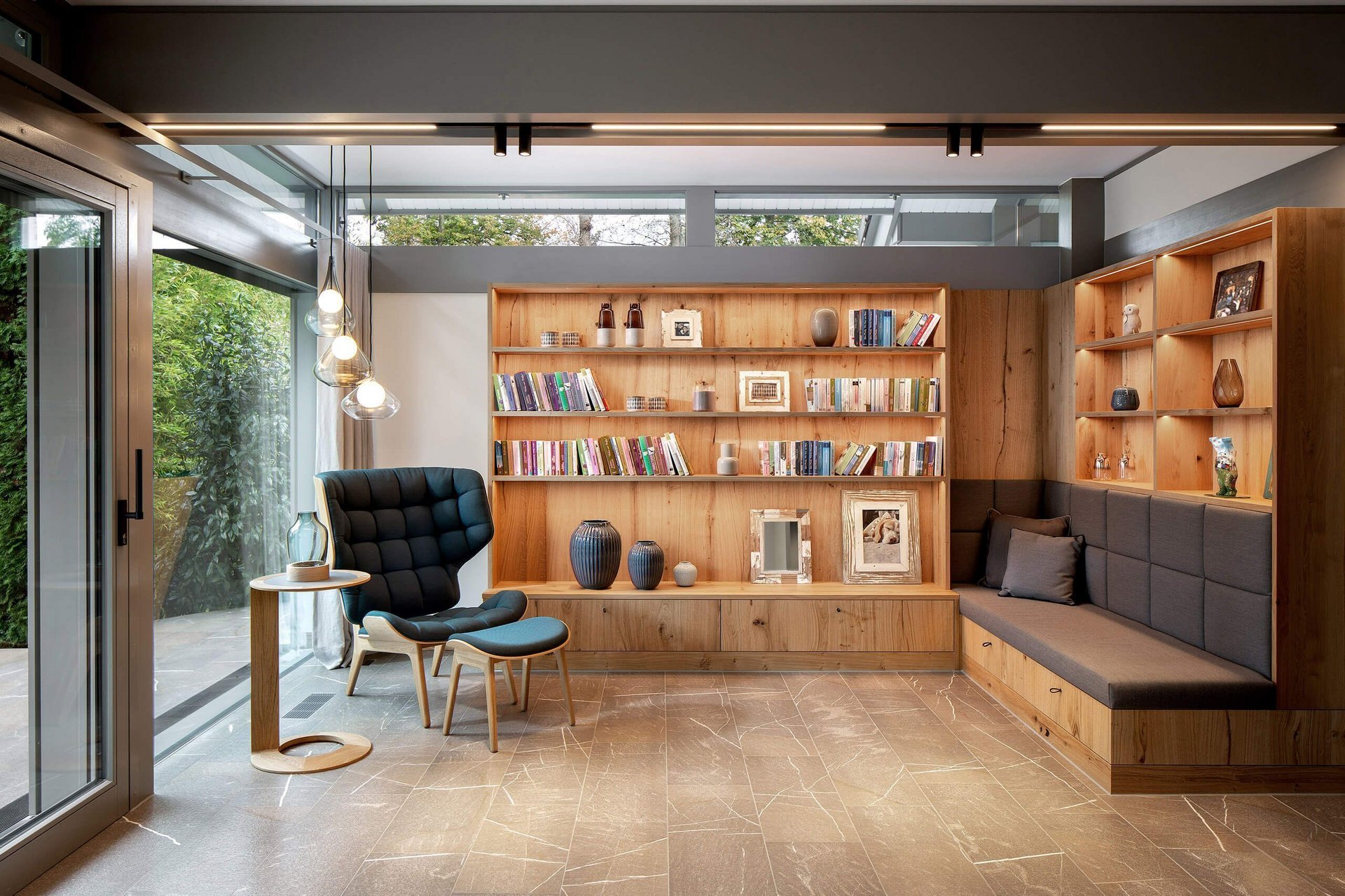 Modernes Wohnzimmer mit Holzmöbeln und Bücherregal Gemütliches Wohnzimmer mit Sitzbereich und modernen Elementen