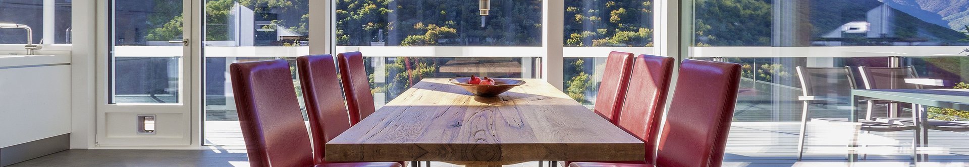Modern Dining Room with Scenic View Bright dining area featuring red chairs and large windows