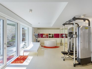 Moderne Innenansicht mit Fitnessgerät und eleganter Badewanne
