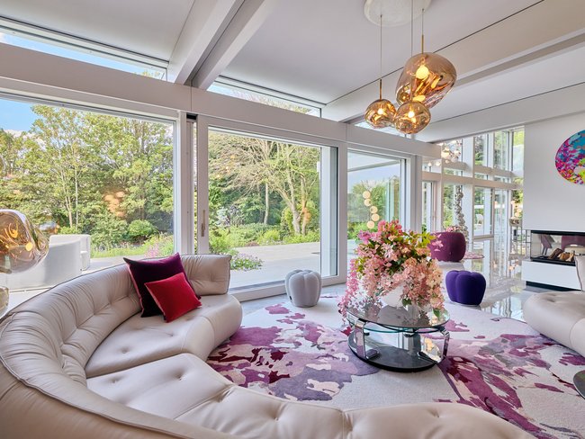 Eleganter Wohnraum mit großen Fenstern und stilvollen Möbeln