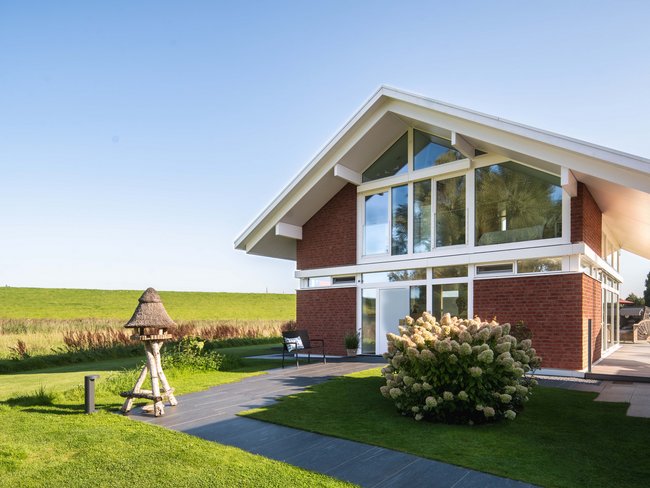 Modernes Familienhaus mit großen Fenstern und schöner Landschaft