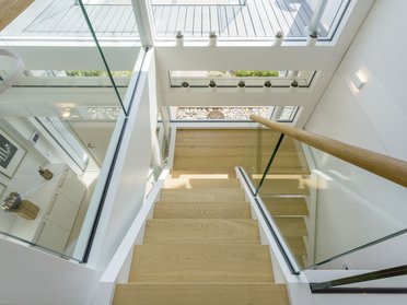 Blick von oben auf das Treppenhaus einer modernen Villa mit Glasdetails