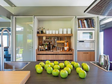 Einblick in eine moderne Küche mit großzügigem Design und grünen Äpfeln