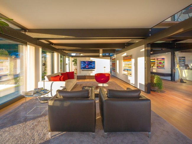 Helle und stilvolle Lounge mit Fernseher und Kunstwerken.