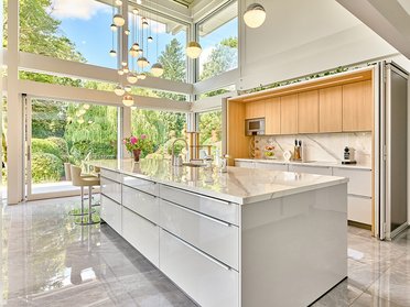 Helle, offene Küche in einer zeitgenössischen Architektur mit großen Fenstern