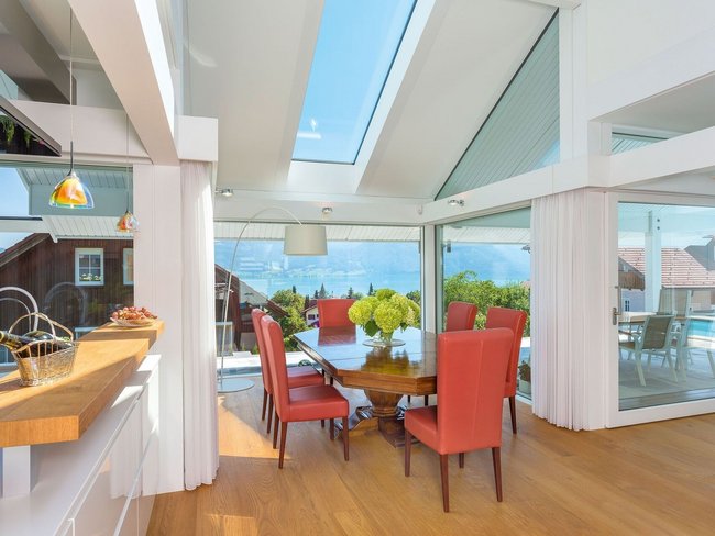 Helles Interieur mit Blick auf Hügel und See