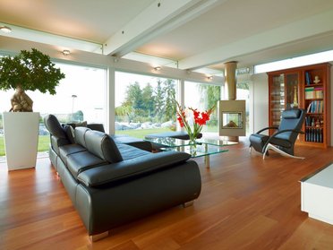Moderne Architektur im HUF HAUS ART 4 Elegantes Wohnzimmer mit Gartenblick und moderner Einrichtung