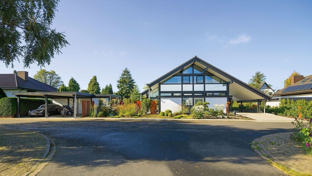 Transparentes Fachwerkhaus mit Garten und Panorama Moderne Architektur eines Fachwerkhauses mit Glas und Holz, umgeben von Garten und Natur