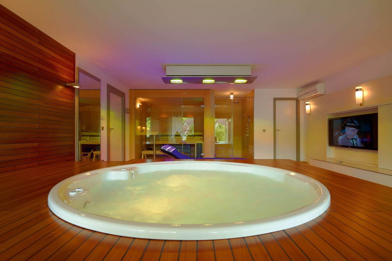 Wellnessbereich mit Whirlpool und stilvollem Holzinterieur in einem HUF HAUS