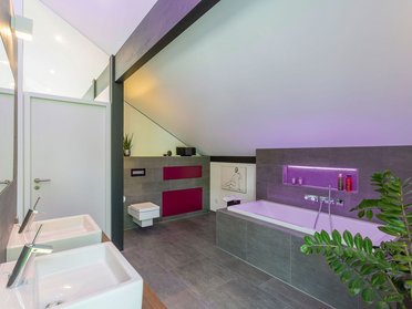 Gemütliches und stilvolles Badezimmer mit Badewanne und modernen Waschbecken