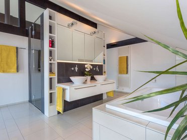Helles Badezimmer mit Doppelwaschbecken und moderner Dusche