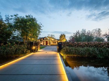 Bungalow mit organischen Formen und Glasflächen Bungalow in traumhafter Landschaft mit Wasserwegen und alten Bäumen