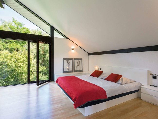 Ein stilvolles Schlafzimmer mit großen Fenstern und minimalistischem Design