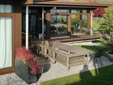 Modernen Bungalow mit Garten und Terrasse Architektenhaus mit Holzverkleidung, Gartenmöbel und schöner Landschaft