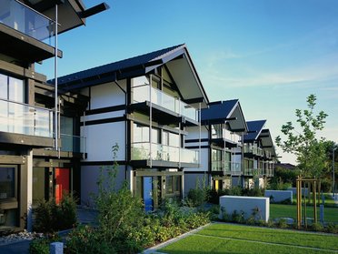 Moderne Wohngebäude mit Balkonen und Gartenanlagen Reihe von modernen Häusern mit klaren Linien und grünen Flächen