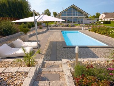 Fachwerkhaus HUF HAUS ART 4 mit Poollandschaft Schön gestalteter Garten mit Pool und modernen Sitzgelegenheiten