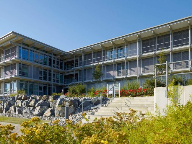 Ansicht des Bürogebäudes HUF mit Pflanzen und Treppen
