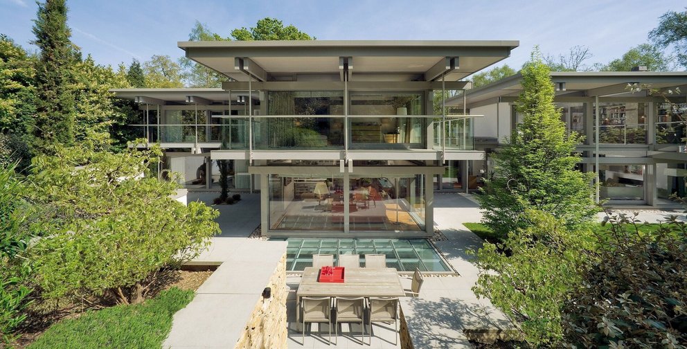 Ein stilvolles, zeitgenössisches Haus mit Glasfassade und Garten