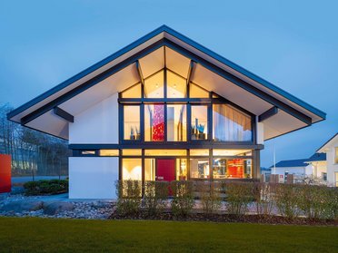 Futuristisches Haus mit Glasfront und stilvollem Design bei Dämmerung